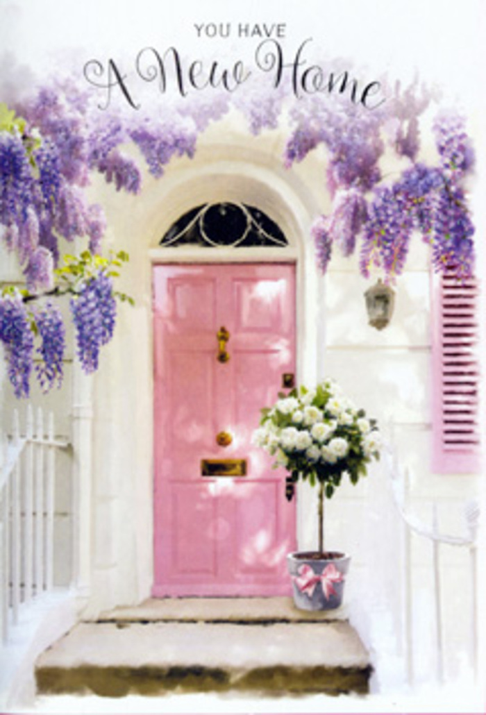 This image shows a lovingly curated doorway in Bayswater that feels like a blessing placed right on the threshold. The focal point is a soft pink front door, its colour delicate yet confident, set into whitewashed walls that catch the light with a powdery brightness reminiscent of hidden lanes off Westbourne Grove. To one side, a matching painted shutter leans open, hinting at a home that embraces sunlight and fresh air. Overhead, mature wisteria weaves across the entry, its branches heavy with lavender blossoms that drape like velvet curtains. Each hanging cluster of blooms creates layers of colour and texture, from pale lilac tips to deeper mauve shadows, forming an arch that frames the door with natural romance. Just at the step sits a rustic grey metal bucket, clearly chosen with care by an experienced florist. It brims with creamy white roses, their rounded heads full and generous, interspersed with sprigs of soft, silvery-green foliage that spill casually over the edge. A satin pink ribbon is tied neatly around the bucket, its sheen catching the light and linking the bouquet to the pastel door. The composition is tranquil yet emotionally charged, evoking the gentle excitement of moving into a new flat near Hyde Park or along Bayswater Road. You can almost imagine the quiet of the side street, the faint distant sounds of the city, and this floral arrangement waiting patiently to greet its new owners. The whole scene feels like a tender housewarming gesture: understated, elegant, and rich with the promise of friendship, comfort, and future memories behind that welcoming pink door.